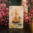 Karte mit der Aufschrift "SCHIFF" und der Nummer 3, zeigt ein kunstvolles Segelschiff in einer bunten Illustration, umgeben von Blumen.