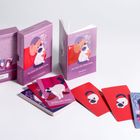 "Die Katze des Dalai Lama - Weisheitsorakel" mit Karten und Buch. Illustrationen von Katzen auf lila und roten Hintergründen.