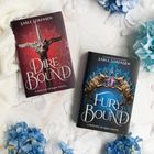 Buchcover: "Dire Bound" in Rot mit Schwertmotiv, "Fury Bound" in Blau mit Drachenköpfen, umgeben von blauen Blüten.