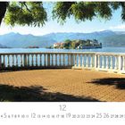 „Die drei Inseln“, Kalenderblatt für Dezember. Eine Terrasse mit Blick auf einen See, Hintergrund Berge und Insel.