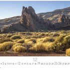 Teide Nationalpark. Zeigt felsige Landschaft mit goldbrauner Vegetation im Vordergrund und markanten Bergformationen.