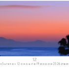 "Blick auf Fuerteventura." Dezemberkalender mit Bild eines Sonnenuntergangs über dem Meer, silhouettierte Palmen im Vordergrund.
