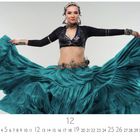 CASARES EDITION. Frau in traditionellem Tanzkostüm, hält grünen Rock weit ausgebreitet, lächelt, trägt Schmuck und Kopfschmuck.