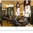 Café Griensteidl; Dezember; Menschen sitzen an Tischen in einem gemütlichen Café mit klassischen Holzstühlen und roten Vorhängen.
