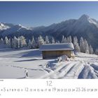 Winterlandschaft mit Holzhütte im Schnee, umgeben von schneebedeckten Bäumen, mit Bergen im Hintergrund.