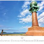 Struve Bogen Hammerfest. Eine Statue mit einer Weltkugel auf einer Säule vor blauem Himmel mit Wolken, im Hintergrund Berge.