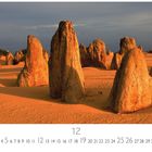 "The Pinnacles", Dezemberkalender, orangefarbene Felsformationen in Wüste bei bewölktem Himmel.