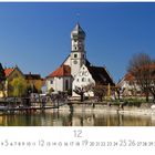 „Wasserburg“ steht links unten. Im Hintergrund sind bunte Häuser, eine Kirche mit Zwiebelturm und ein Hafen zu sehen.