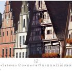 "Dinkelsbühl, Weinmarkt" über traditionellen Fachwerkhäusern mit blühenden Blumen und einer großen Uhr an einem Gebäude.