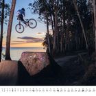 Kalenderseite für Dezember; BMX-Fahrer springt bei Sonnenuntergang über Rampe in einem Wald mit Eukalyptusbäumen.