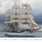Kalender zeigt Dezember-Daten vor einem großen weißen Segelschiff mit offenen Segeln auf dem Meer.