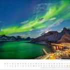 „dezember“ auf weißem Hintergrund; Polarlichter über verschneiter Küstenlandschaft und beleuchtetem Dorf.