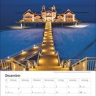 Kalenderseite für Dezember. Im oberen Teil eine beleuchtete Seebrücke bei Nacht, die ins Meer führt.