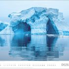 Text „DEZEMBER“. Ein großer, majestätischer Eisberg spiegelt sich im ruhigen Wasser.