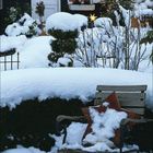 „No. 7“ neben einer Tür. Schnee bedeckt alles, Bank und Tannenbaum mit Lichtern. Dezemberkalender unten.