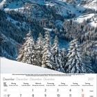Dezember 2027 Kalender mit verschneiter Berglandschaft, Tannen im Vordergrund, klarer Himmel.