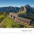 Kalenderblatt von Oktober 2027 mit Berglandschaft und einer Hütte.
