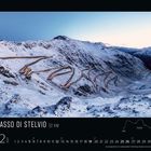 Passo di Stelvio 32 KM, 12 2023. Schneebedeckte Serpentinenstraße in bergiger Landschaft bei Sonnenaufgang.