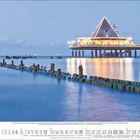 Kalenderseite Dezember 2023 mit Tagen und Woche. Abendansicht eines hell erleuchteten Pavillons über einem See auf Pfählen.