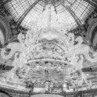 "La Parisienne ist eine Legende." Ein festlich dekorierter, prächtiger Raum mit einem großen Baum und reich geschmückter Decke.