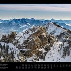 12. Ausblick vom Wendelstein. Ein schneebedeckter Berg mit Fichten und weitem Alpenpanorama im Hintergrund.