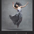 Kalender, Dezember, tanzende Frau in grauem Kleid schwebt anmutig, Kopf zurückgeworfen, Haare fliegen dynamisch.