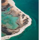 "Dezember" und darunter eine Kalenderübersicht. Luftaufnahme einer Küstenlinie mit türkisfarbenem Wasser und Sand.