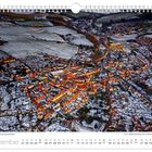 Dezemberkalenderbild mit Stadt im Schnee, beleuchteten Straßen, und "Winterstimmung in Dippoldiswalde" beschrieben.