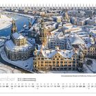 Dezemberkalender mit schneebedeckter Altstadt, zeigt historische Gebäude entlang eines Flusses.