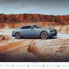 DEZEMBER-Kalender. Elegantes blaues Auto in einer sandigen Landschaft mit Felsen im Hintergrund.