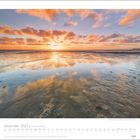 Dezember 2027 Kalenderblatt, "Inseln & Meer". Sonnenuntergang spiegelt sich im nassen Sand eines ruhigen Strandes.