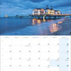 Kalender für Dezember 2027. Feiertage wie Nikolaus, Winteranfang, Weihnachten und Silvester sind markiert. Ansicht einer Seebrücke bei Sonnenuntergang.