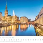 Dezember 2027, Hamburg. Kalenderansicht mit illuminiertem Rathaus und Alsterarkaden bei Dämmerung.