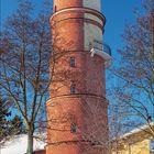 Dezember 2027 Kalender. Leuchtturm von 1827, Travemünde, Deutschland. Schneelandschaft, blauer Himmel und Karte der Ostsee.