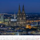 "12 2027", "Köln", Monatskalender; nächtliche Skyline mit beleuchtetem Dom, umgeben von erleuchteten Gebäuden.