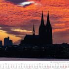 Text: "Köln - Silhouette der Hohen Domkirche St. Petrus". Kölns Dom-Silhouette beim dramatischen Sonnenuntergang im Hintergrund.