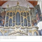 Neue Kirche in Amsterdam, Niederlande. Große Orgel mit goldenen Verzierungen und Malereien an den Seiten. Kalender rechts.