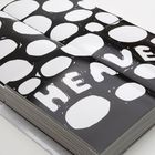 „HEAVEN“ in weißen Buchstaben auf schwarz. Große, weiße ovale Formen als Hintergrund. Ein Buch liegt offen.