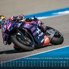 Kalender im Vordergrund, Motorradfahrer in violetter Rennkleidung und Helm, Marke „Yamaha“ auf dem Bike.