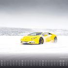 Kalender mit Lamborghini Huracán im Schnee. Gelbes Auto fährt dynamisch auf verschneiter Landschaft.