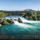 Kalendarium unten, „Rheinfall 12“. Wasserfall mit grünem Wasser, Bäume, Brücke und Gebäude umliegend.