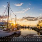 Fischerhafen Bremerhaven und 12. Vorne Boote im Hafen, Sonnenuntergangsstimmung, Wasser reflektiert Farben des Himmels.