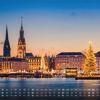 Text: "Weihnachtsmarkt 12". Kalenderansicht unten. Weihnachtlich beleuchtete Stadtansicht mit großen Tannenbaum.