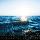 Kalender mit Tagen und Daten in Weiß unten. Sonniger Ozean mit Wellen im Vordergrund.