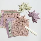 Farbige, gemusterte Origamipapiere und fertige Origamiblätter in Pastelltönen, teils mit floralen Motiven.