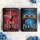 Die Buchrücken zeigen "Fury Bound" und "Dire Bound" von Sable Sorensen. Farbiger Hintergrund mit blauen und rosa Blüten.