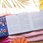 Kapitel 1, dekoratives Muster auf einem Buch mit bunten Blumen; Schatten und pastellfarbenes Tuch im Hintergrund.