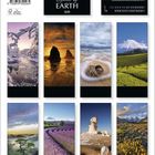 "2027", "Spirit of EARTH". Ein Kalender mit einem Sonnenuntergang und Blumen hängt an einer grünen Wand.