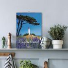 Kalender: "Deutschland 2024", zeigt einen Leuchtturm, umgeben von Lavendel, an einer Wand über einem Regal mit Pflanzen.