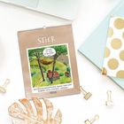 Kalenderblatt "STIER" mit Datum 21.04. - 20.05., Illustration einer ruhenden Figur in einer Hängematte zwischen Bäumen.